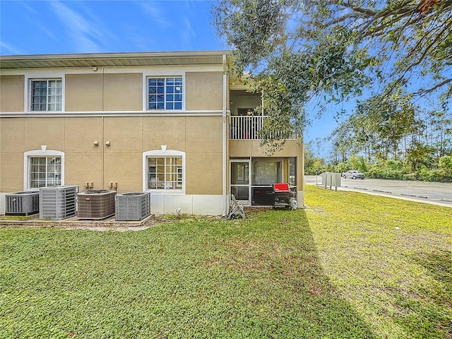 rear view of house with a yard and central AC unit