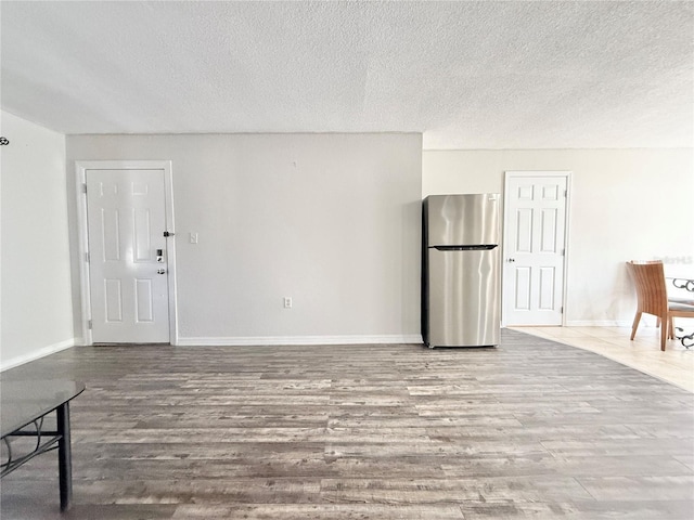 unfurnished living room with hardwood / wood-style flooring and a textured ceiling