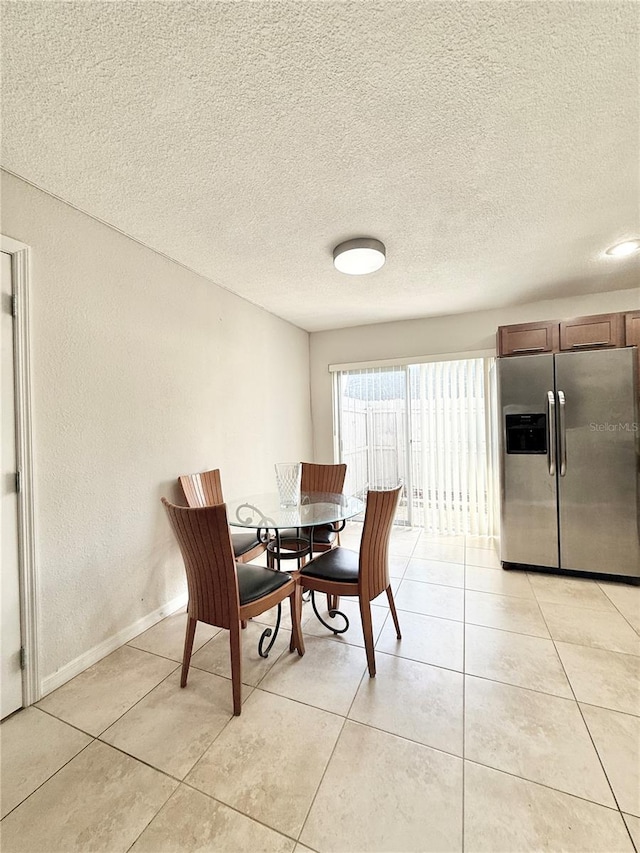 dining space with a textured ceiling and light tile patterned floors