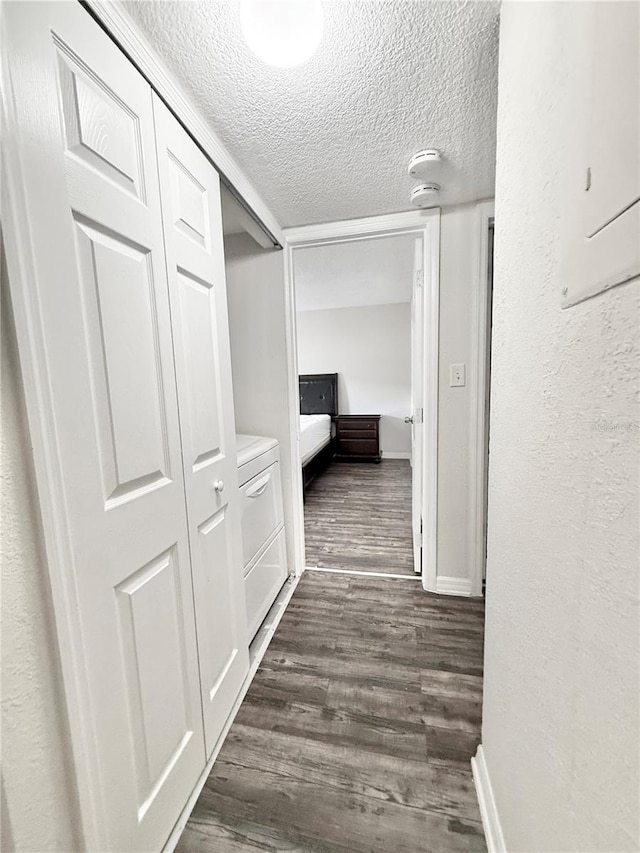 hall with dark hardwood / wood-style floors and a textured ceiling