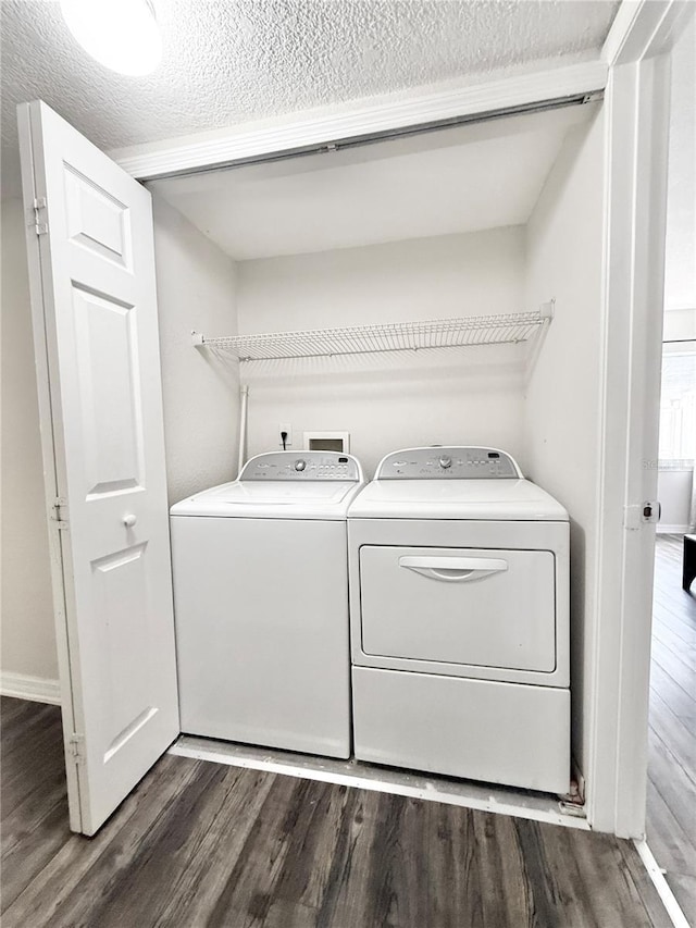 clothes washing area with separate washer and dryer, dark hardwood / wood-style floors, and a textured ceiling