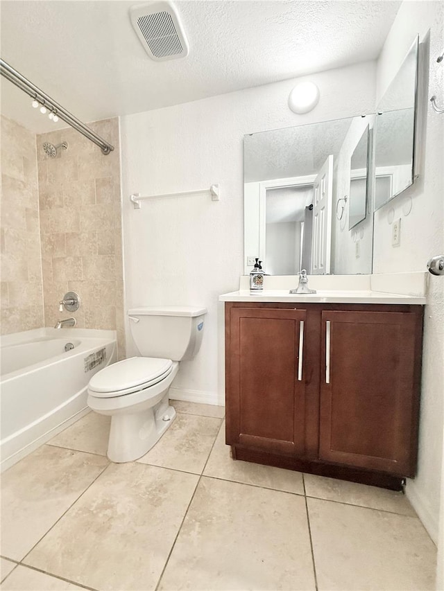 full bathroom with vanity, a textured ceiling, tiled shower / bath, tile patterned floors, and toilet