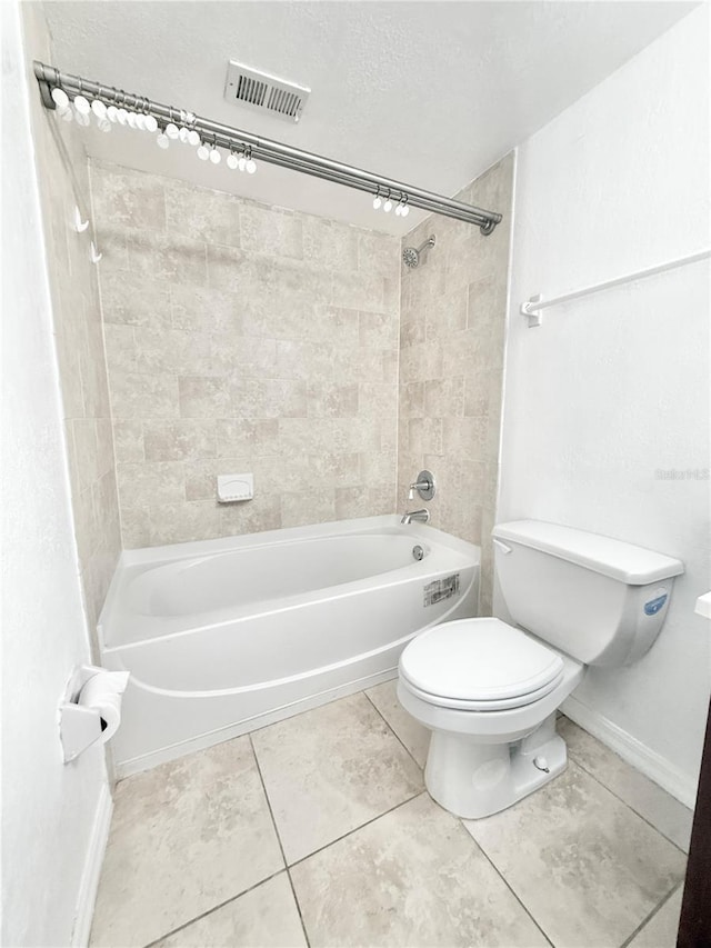 bathroom with toilet, tiled shower / bath combo, and tile patterned flooring