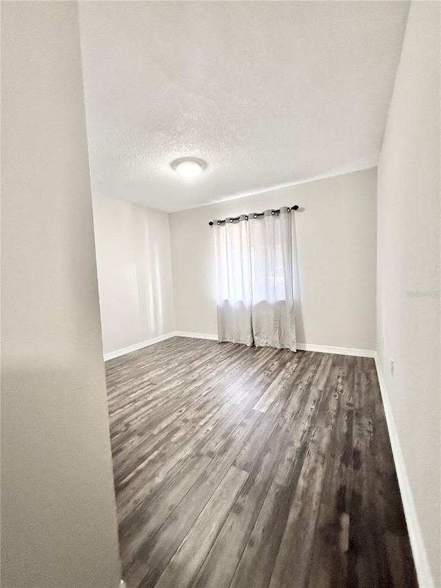 unfurnished room featuring wood-type flooring and a textured ceiling