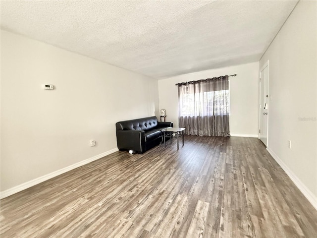 unfurnished room featuring hardwood / wood-style flooring and a textured ceiling