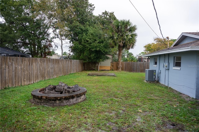 view of yard featuring central AC unit and a fire pit