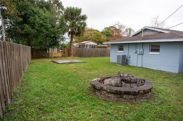 view of yard featuring cooling unit and an outdoor fire pit