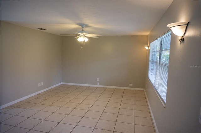 tiled spare room with ceiling fan