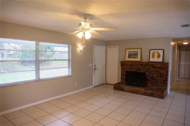 unfurnished living room featuring ceiling fan, light tile patterned floors, and a brick fireplace