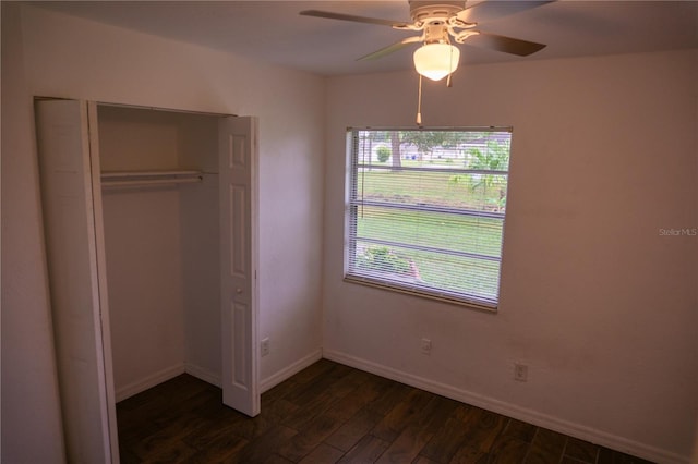 unfurnished bedroom featuring ceiling fan, dark hardwood / wood-style flooring, and a closet