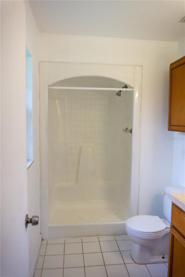 bathroom featuring tile patterned floors, vanity, toilet, and walk in shower