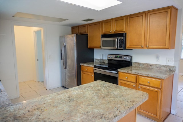 kitchen featuring light tile patterned flooring and appliances with stainless steel finishes