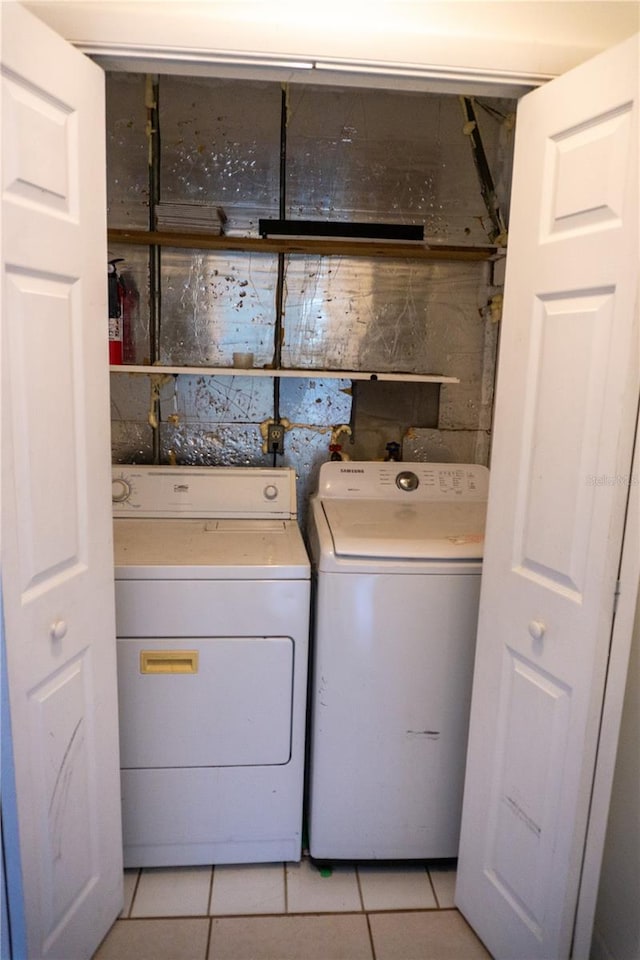 washroom with light tile patterned floors and washer and dryer