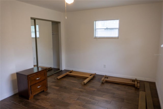 bedroom with dark hardwood / wood-style floors and a closet