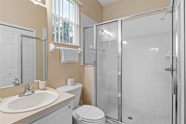 bathroom with vanity, toilet, and a shower with shower door