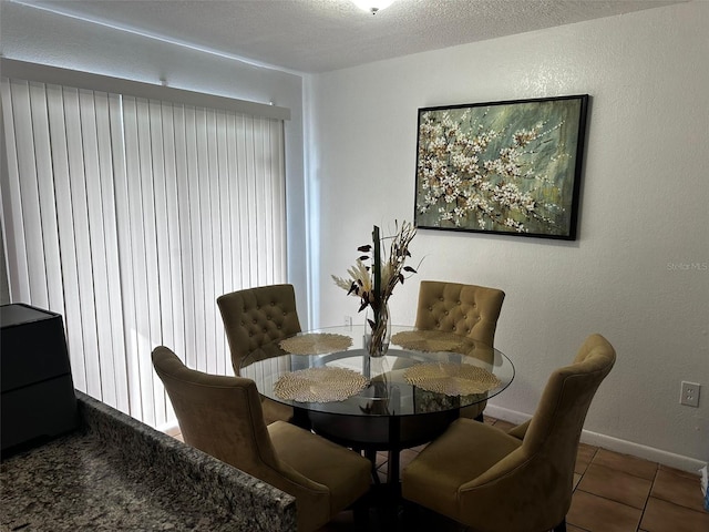 tiled dining area with a textured ceiling