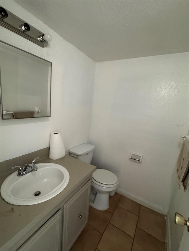 bathroom with tile patterned floors, vanity, and toilet