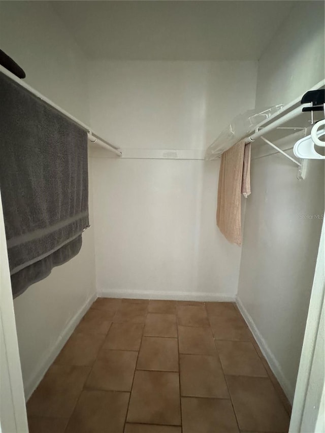 spacious closet featuring dark tile patterned flooring