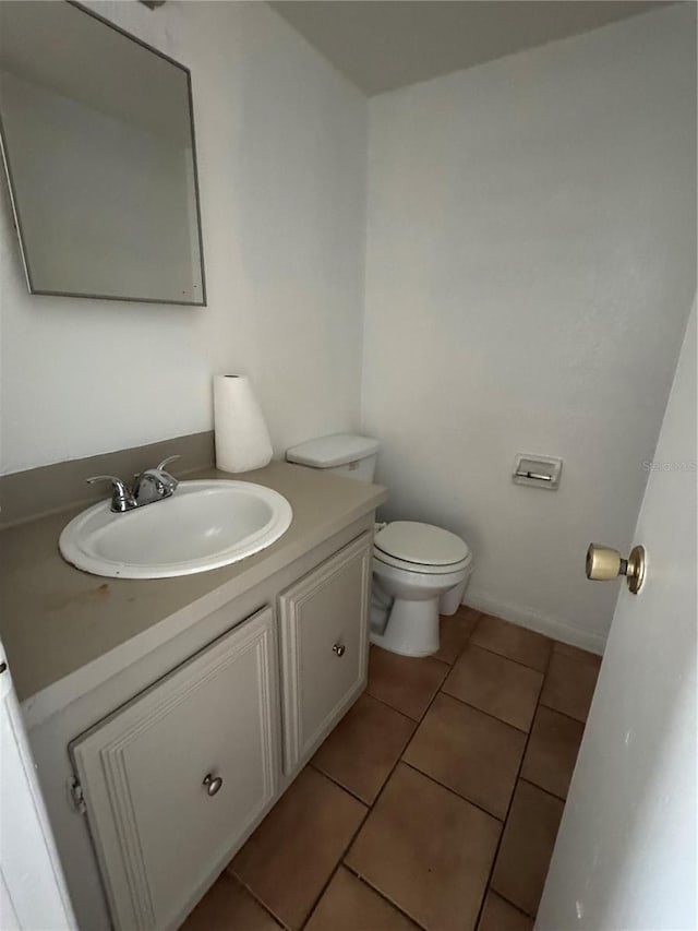 bathroom with tile patterned flooring, vanity, and toilet