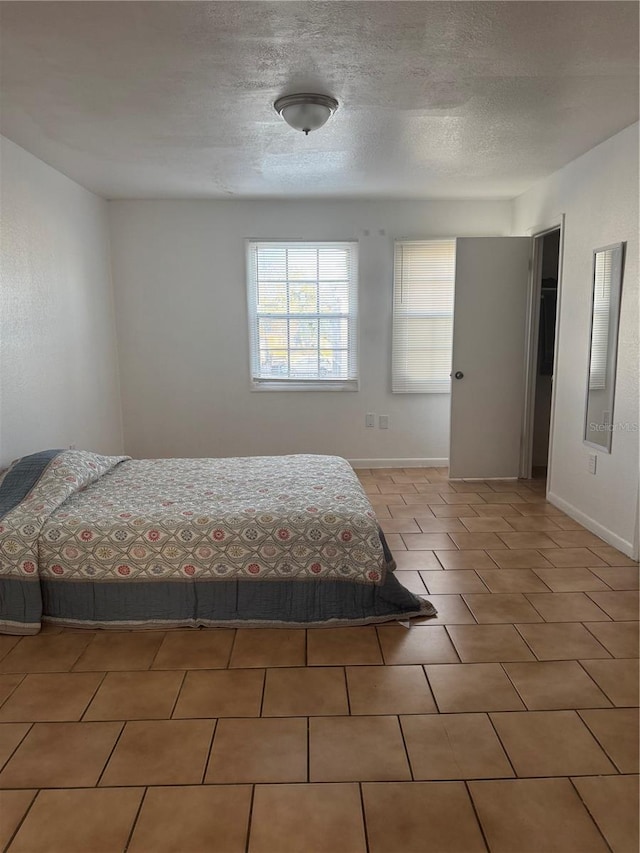 unfurnished bedroom featuring a textured ceiling and tile patterned floors