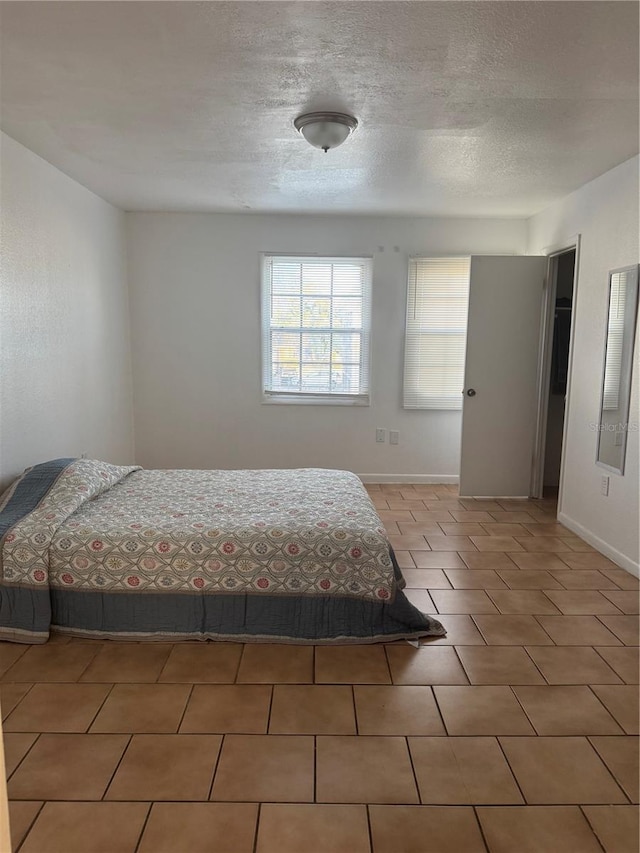 unfurnished bedroom featuring tile patterned floors and a textured ceiling