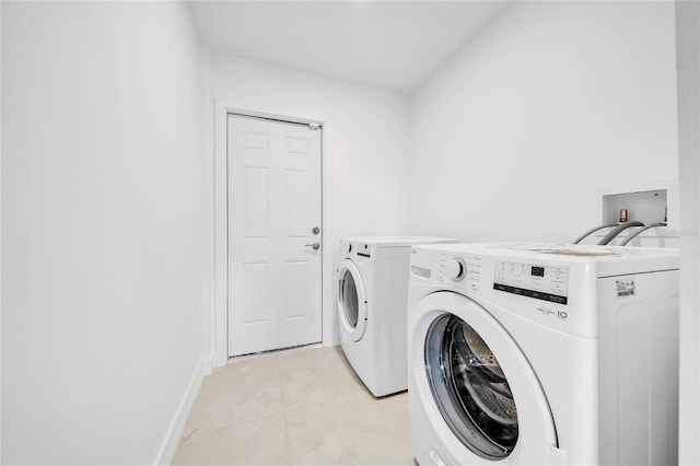 washroom with washer and clothes dryer and light tile patterned floors