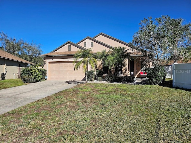 view of front facade with stucco siding, a front yard, a garage, and driveway