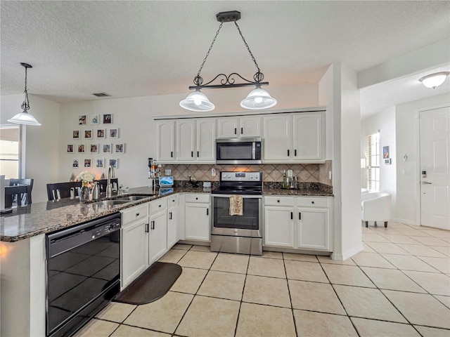 kitchen featuring white cabinets, stainless steel appliances, decorative light fixtures, and light tile patterned floors