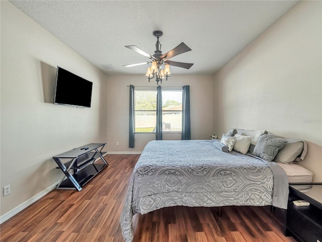 bedroom with dark hardwood / wood-style flooring, a textured ceiling, and ceiling fan