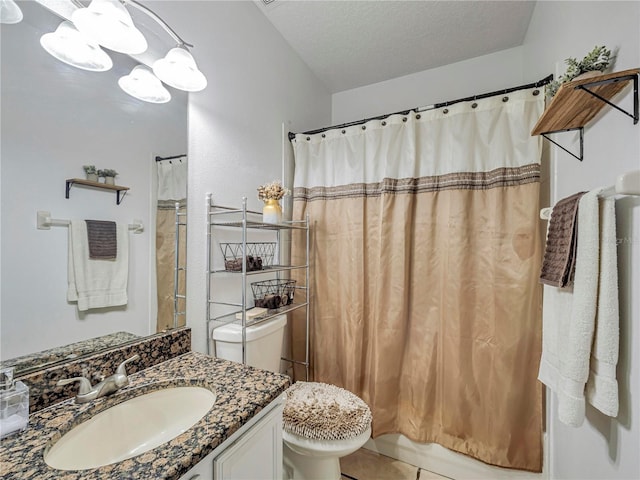 bathroom with toilet, vanity, and a textured ceiling