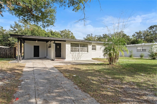 ranch-style home with a carport and a front lawn