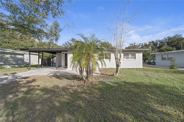 rear view of property with a lawn and a carport