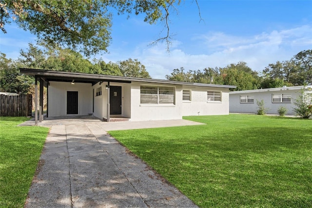 view of front of house featuring a carport, a front yard, concrete driveway, and fence