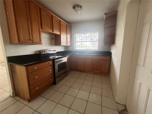 kitchen featuring stainless steel electric range, light tile patterned floors, and sink