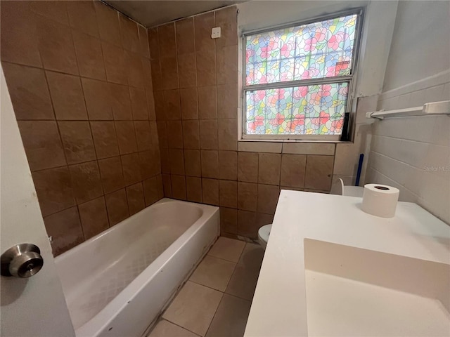 bathroom featuring tile patterned flooring, tub / shower combination, tile walls, and toilet