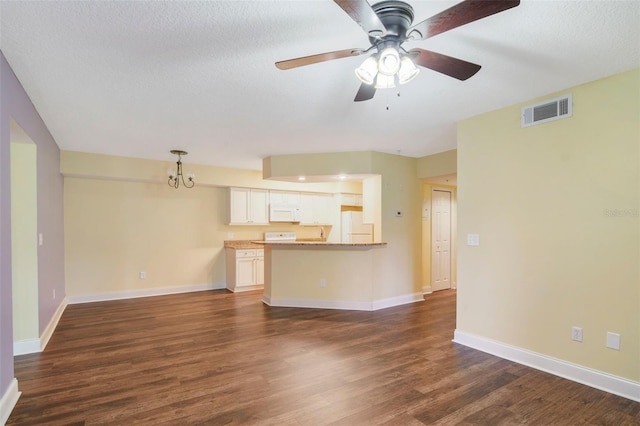 unfurnished living room with ceiling fan, dark hardwood / wood-style flooring, and a textured ceiling