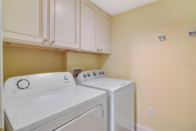 laundry room featuring washing machine and clothes dryer and cabinets