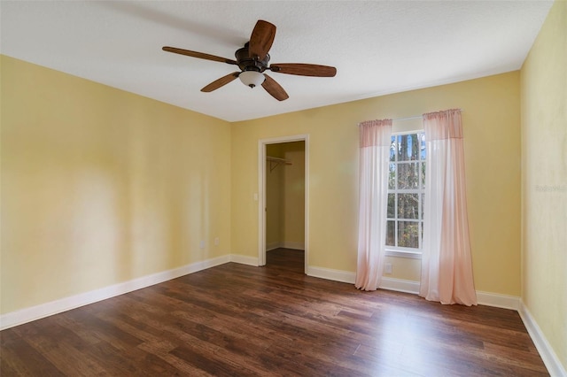 empty room with dark hardwood / wood-style floors and ceiling fan