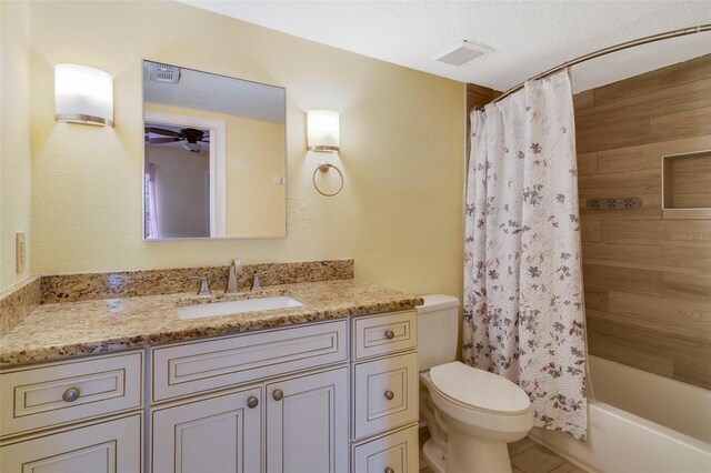 full bathroom with a textured ceiling, vanity, toilet, and shower / tub combo with curtain