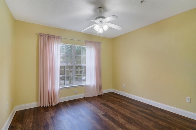 spare room with dark hardwood / wood-style floors and ceiling fan