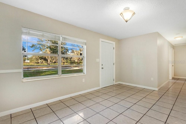 entryway featuring light tile patterned floors and a textured ceiling