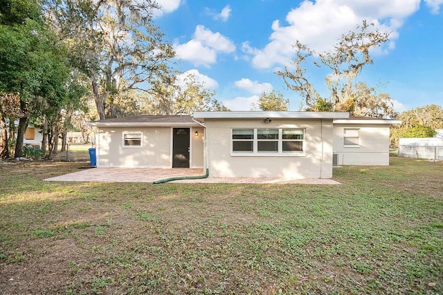 rear view of house featuring a patio and a lawn