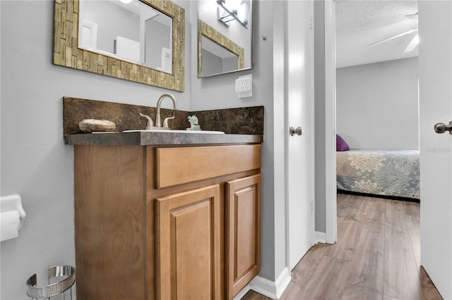 bathroom featuring vanity, hardwood / wood-style floors, a textured ceiling, and ceiling fan