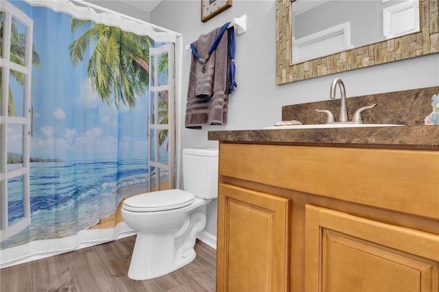 bathroom with hardwood / wood-style floors, vanity, and toilet