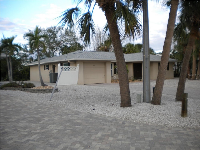 view of front of home featuring cooling unit and a garage