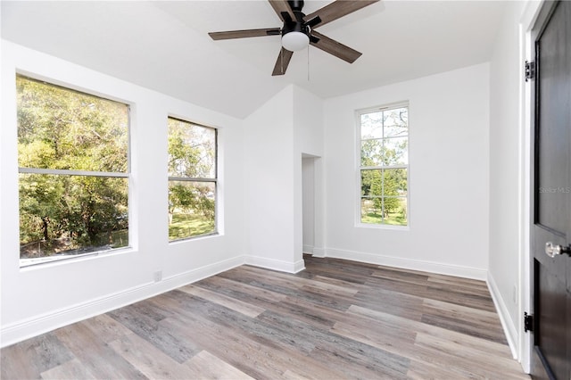 spare room featuring ceiling fan, wood-type flooring, and vaulted ceiling