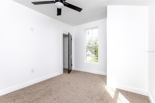 unfurnished bedroom with ceiling fan and light colored carpet