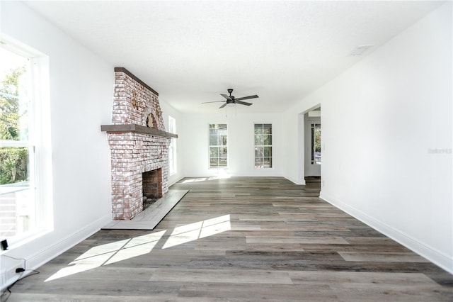 unfurnished living room featuring ceiling fan, dark hardwood / wood-style flooring, and a fireplace