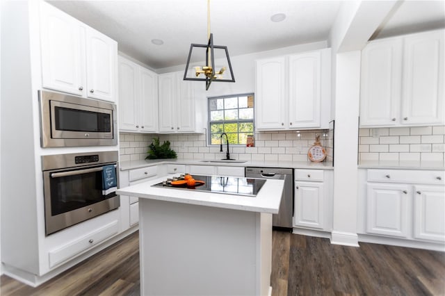 kitchen featuring a kitchen island, sink, white cabinetry, and stainless steel appliances