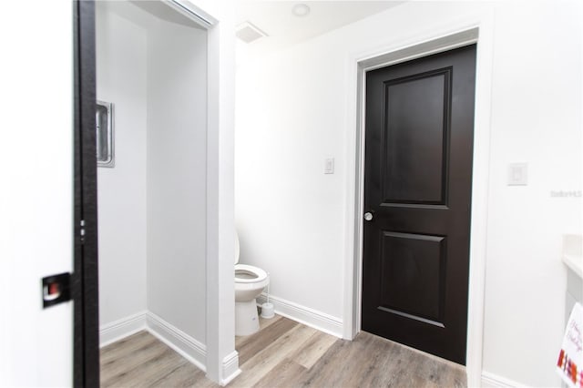 bathroom with wood-type flooring and toilet